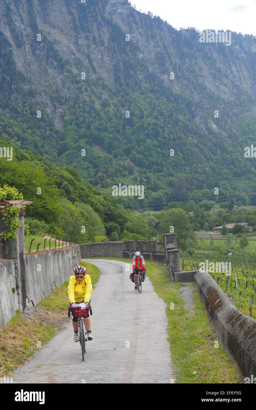 Zwei Radfahrer auf Tour Reiten in einer ruhigen Straße in den Schweizer Alpen. Stockfoto