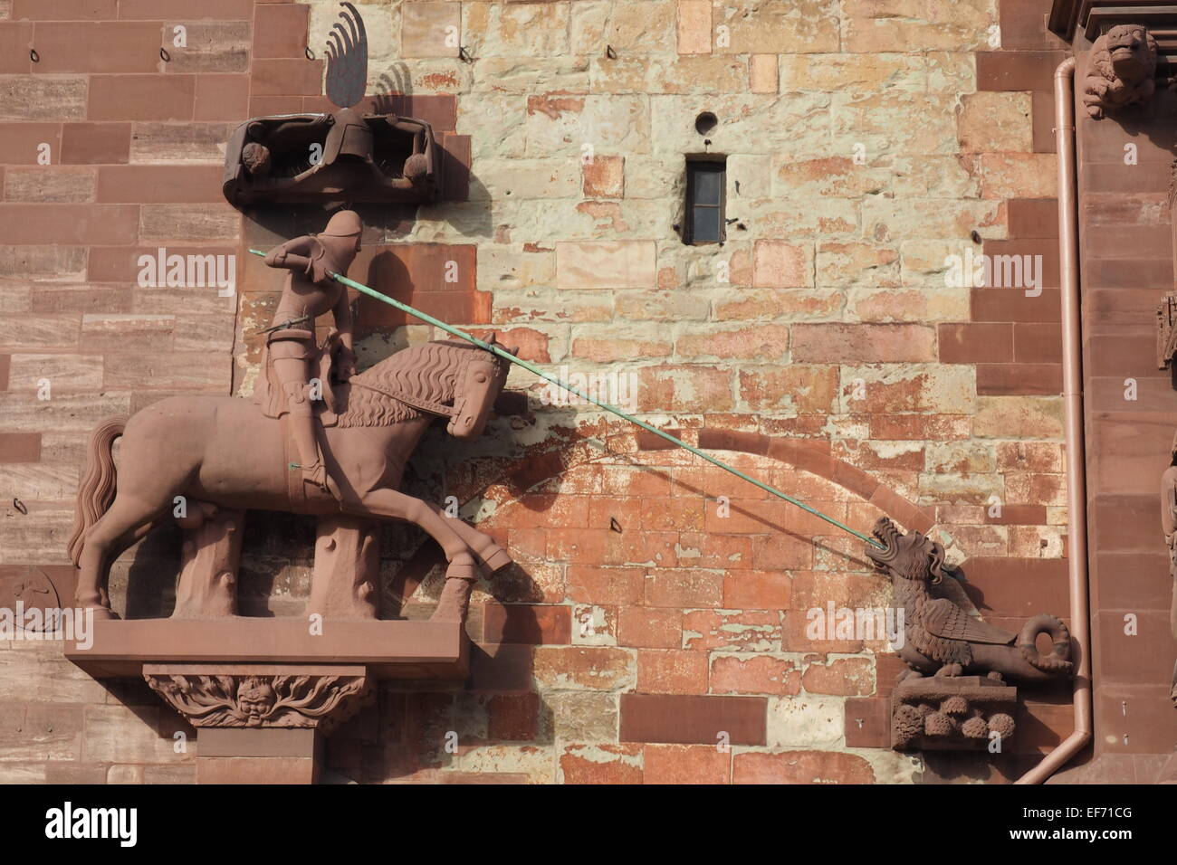 In rotem Sandstein, die Statue von St. George slaying ein Drache, auf der Außenwand der Basler Münster. Stockfoto