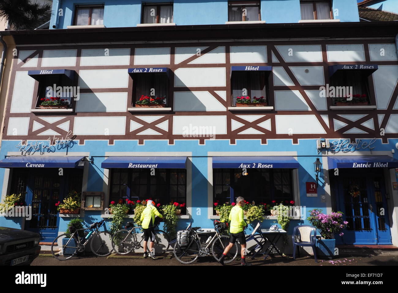 Radfahrer auf einen Radurlaub, ihre Fahrräder Vorbereitung vor dem Hotel Aux 2 Roses in Neuf-Brisach Frankreich, für die Fahrt des Tages. Stockfoto