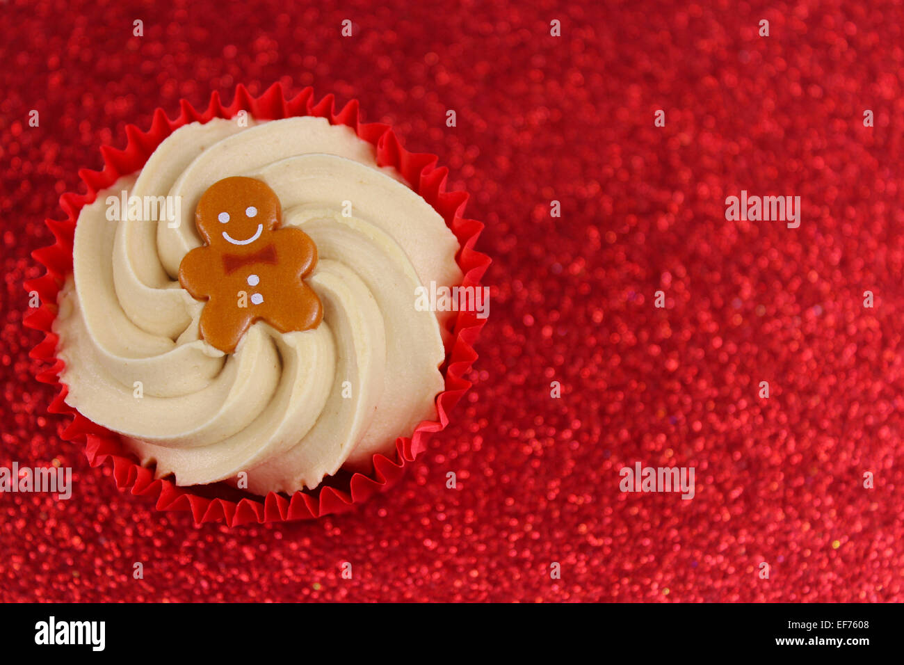 Weihnachten Lebkuchenmann Cupcake auf rot Glitter festlichen Hintergrund mit Textfreiraum. Stockfoto