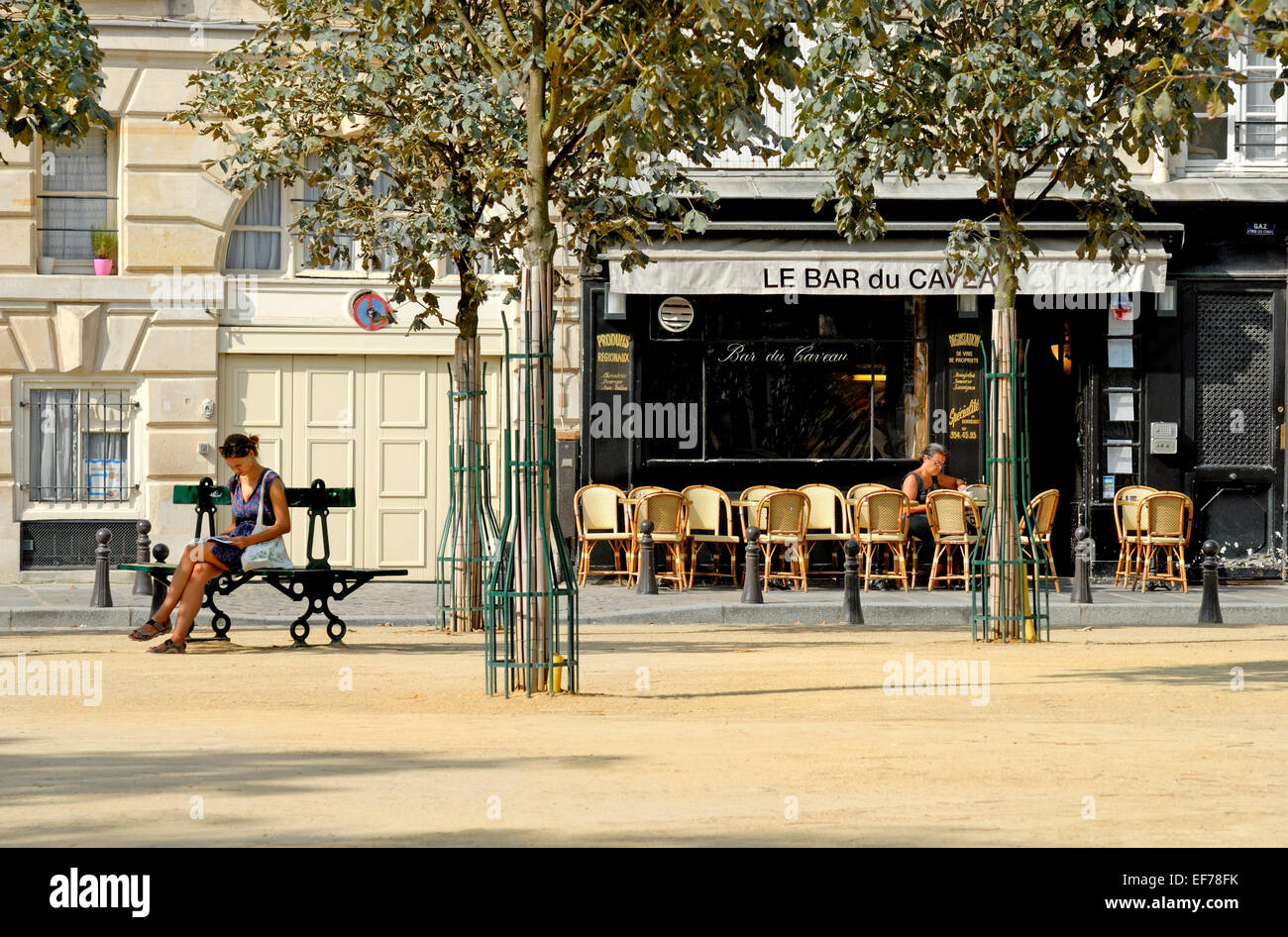 Paris, Frankreich. Restaurant und Frau liest in Place Dauphine auf Isle