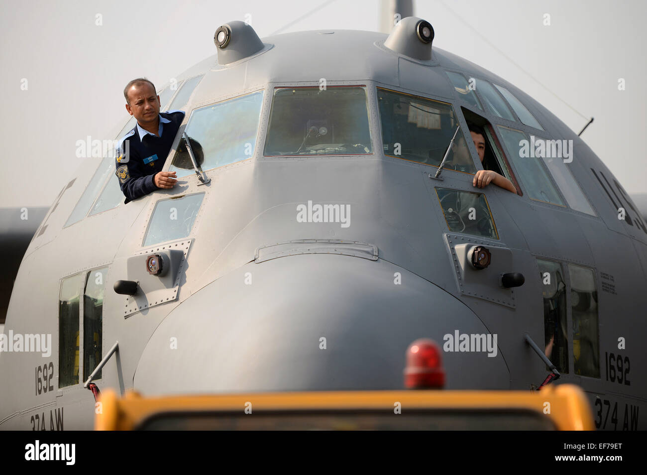Ein Bangladesh Luftwaffe Flieger und US Air Force Crewchief Auge ein auf ihre Flugzeuge der USAF C - 130H wie es während der Übung zu bewältigen Süd 23. Januar 2015 auf BAF Basis Bangabandhu, Bangladesch in eine Parkposition gezogen wird. Stockfoto