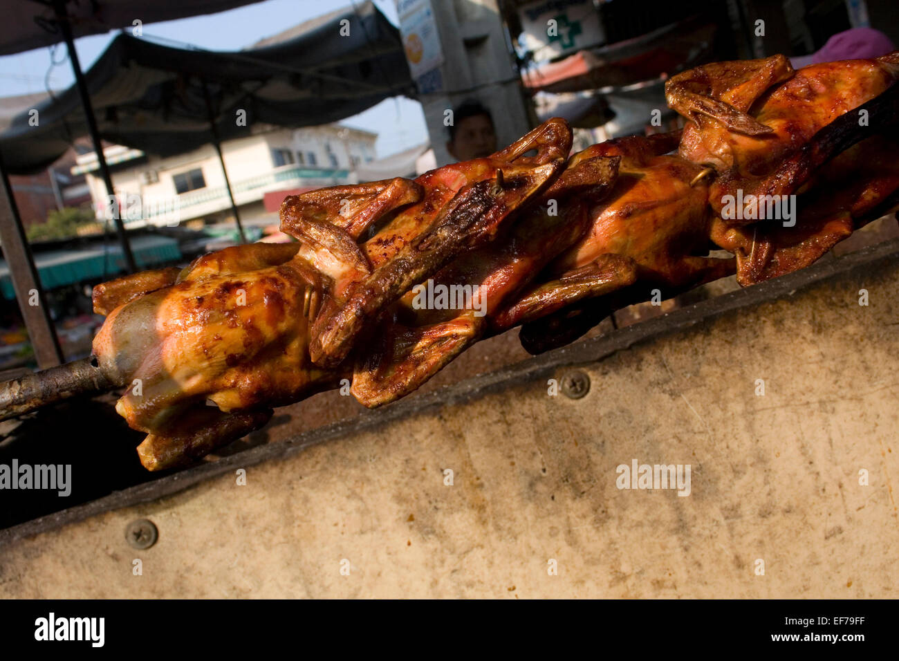 Huhn für bestimmt ein ein mobiles Essen Cart ist langsam rösten über glühende Kohlen auf einer Stadtstraße in Kampong Cham, Kambodscha. Stockfoto