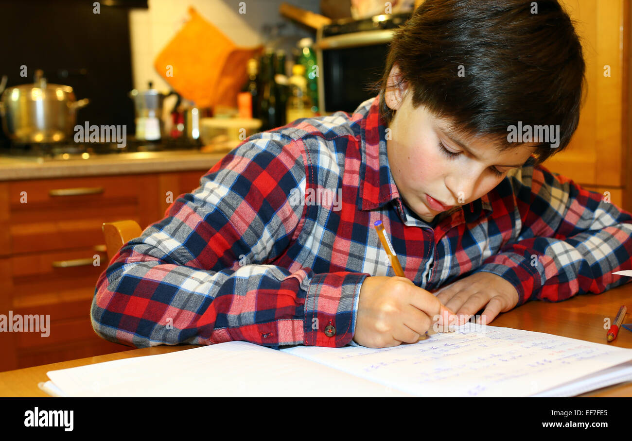 kleiner Junge schreibt auf seinem notebook Stockfoto
