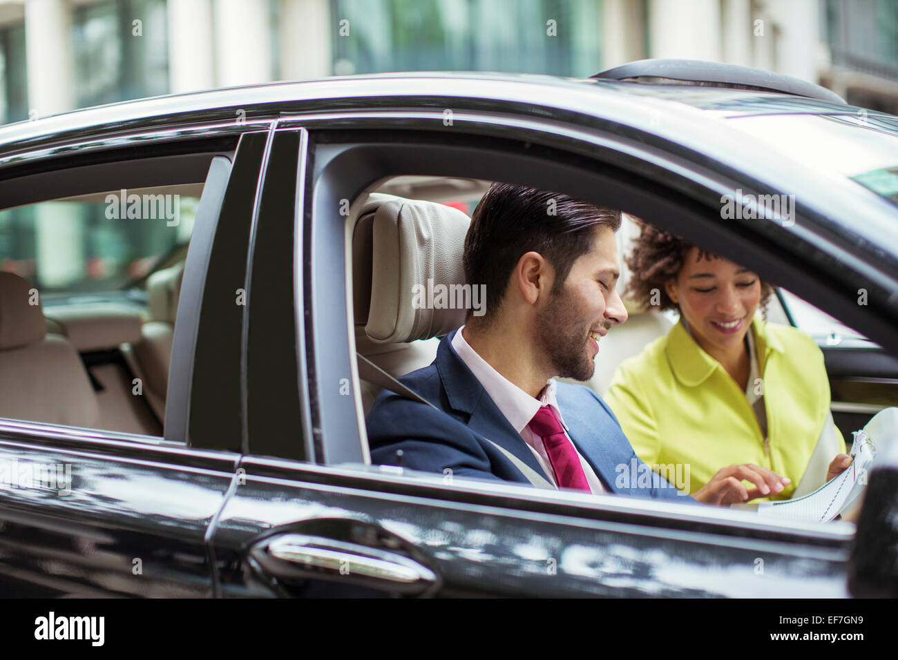 Geschäftsleute, die Schreibarbeit im Auto lesen Stockfoto