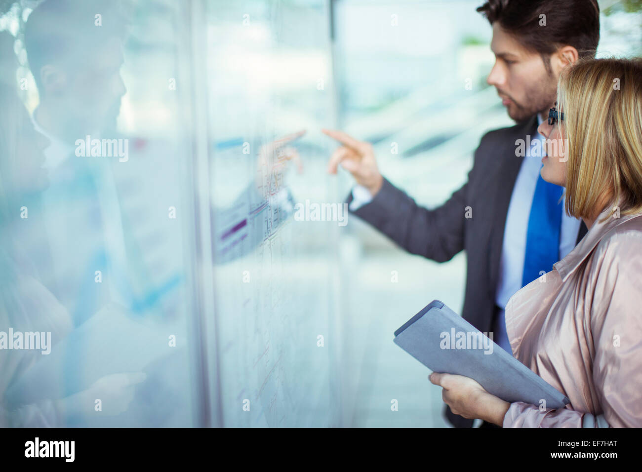 Business-Leute lesen Transport planen am Bahnhof Stockfoto