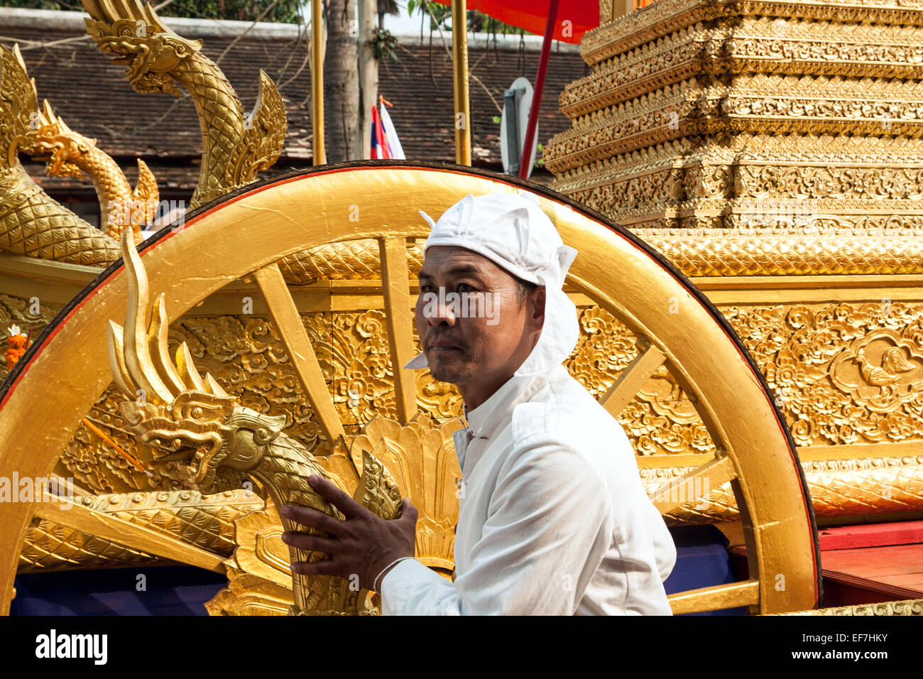 Akolyth schieben eine reich verzierte goldene Kutsche in einer Prozession auf Pi Mai Lao Neujahr in Luang Prabang, Laos. Stockfoto