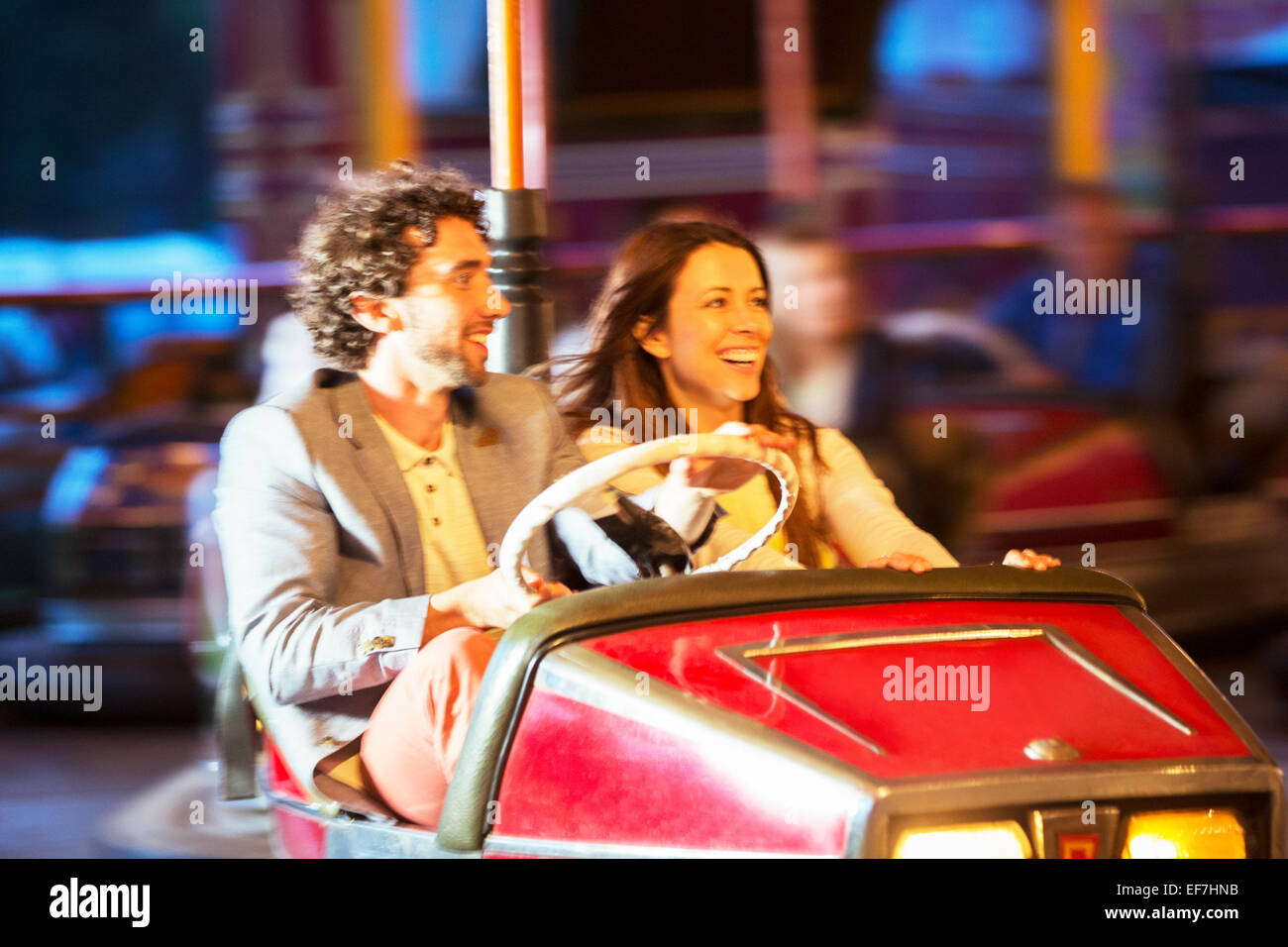 Paar auf Autoscooter fahren im Freizeitpark Stockfoto