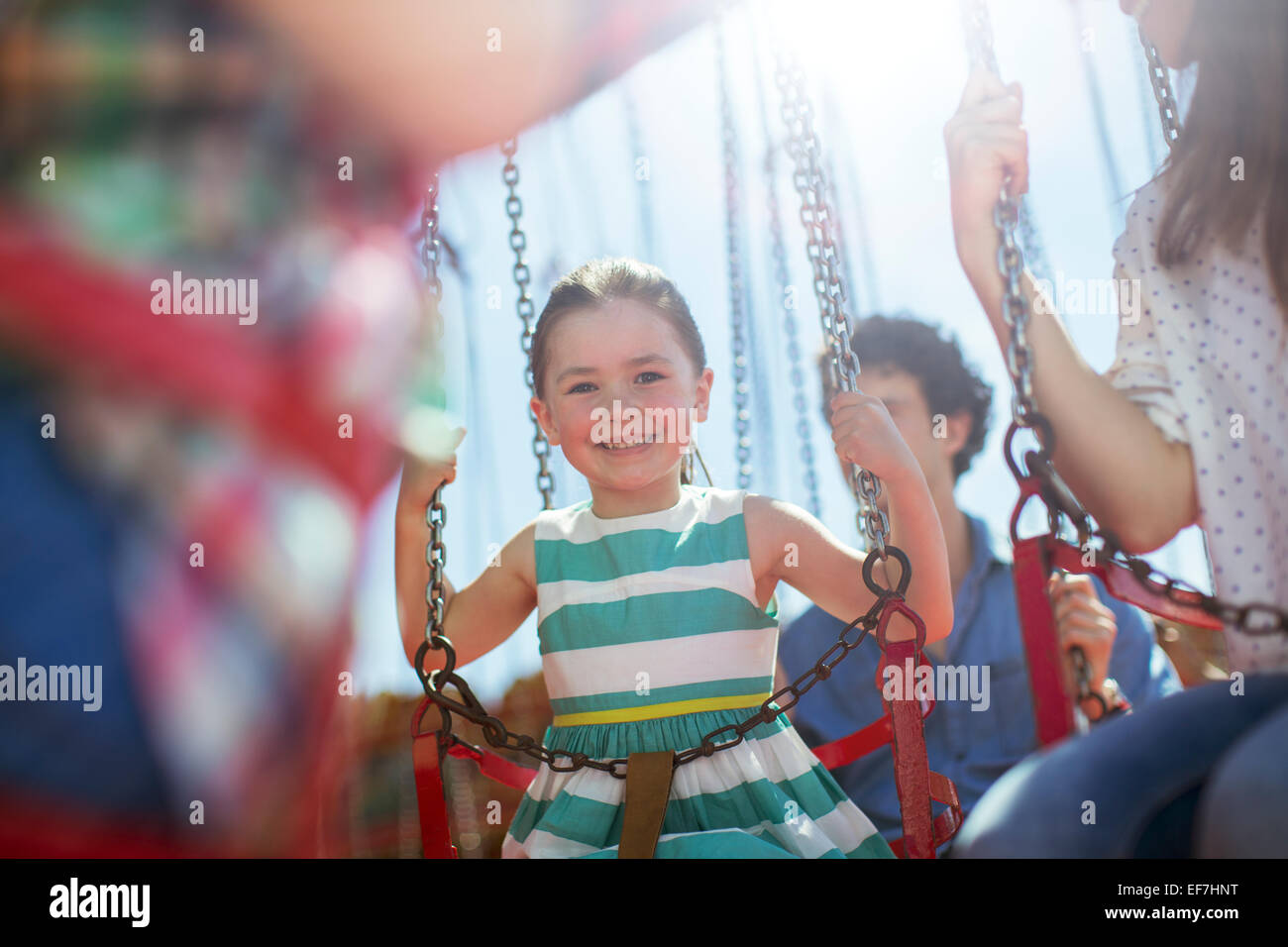 Mädchen lächelnd auf Karussell im Vergnügungspark Stockfoto