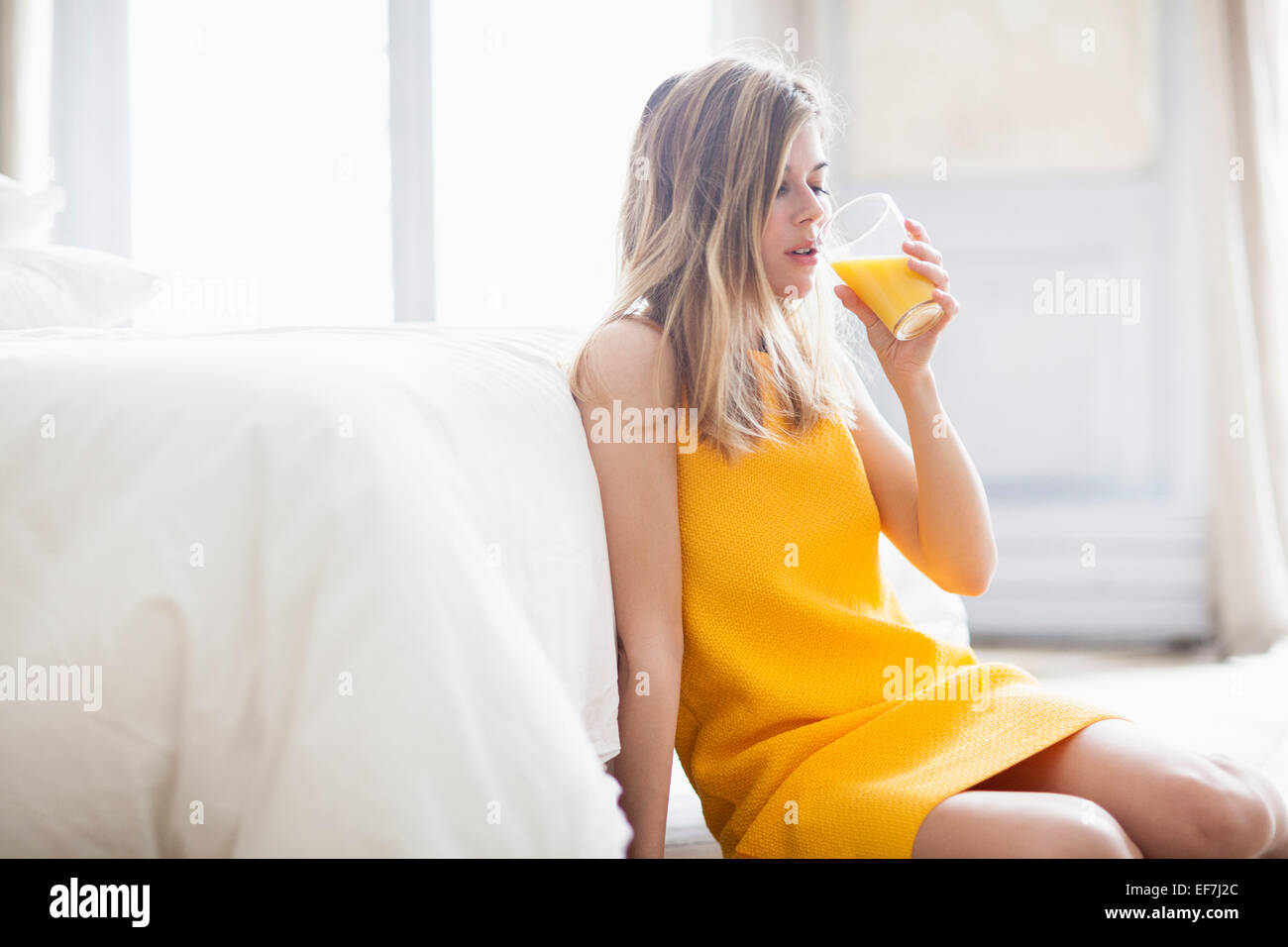 Frau trinkt Orangensaft Stockfoto