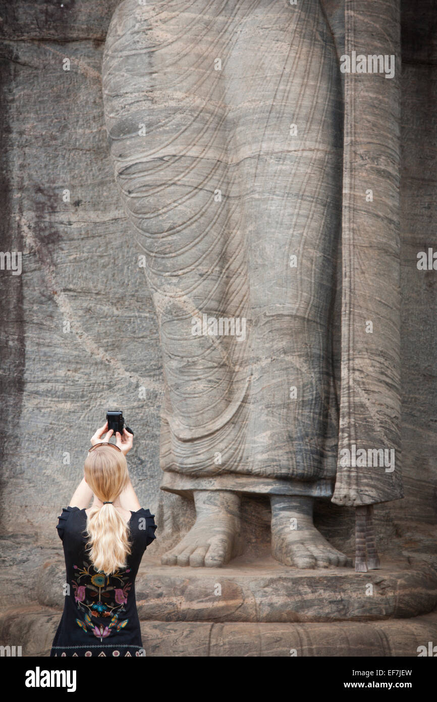 TOURISTISCHEN SNAP AUFNAHME DER RIESIGEN BUDDHA-STATUE AUF LOTUS SOCKEL; GAL VIHARA FELSENTEMPEL Stockfoto