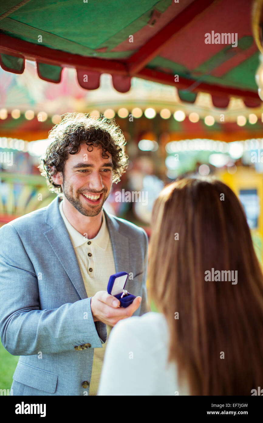 Mann schlägt vor, Freundin im Freizeitpark Stockfoto