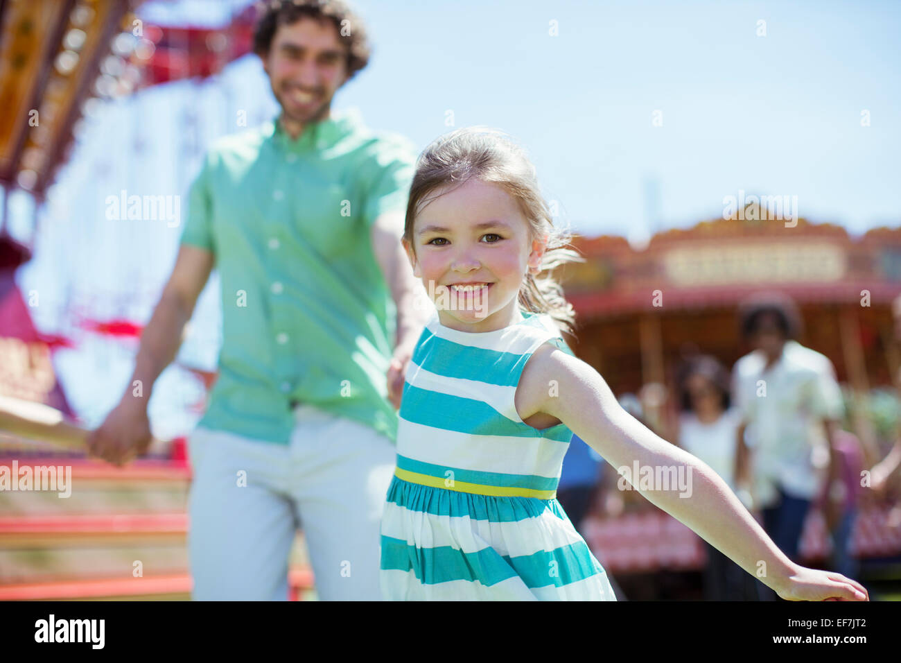 Mädchen ziehen ihr Vater im Vergnügungspark Stockfoto