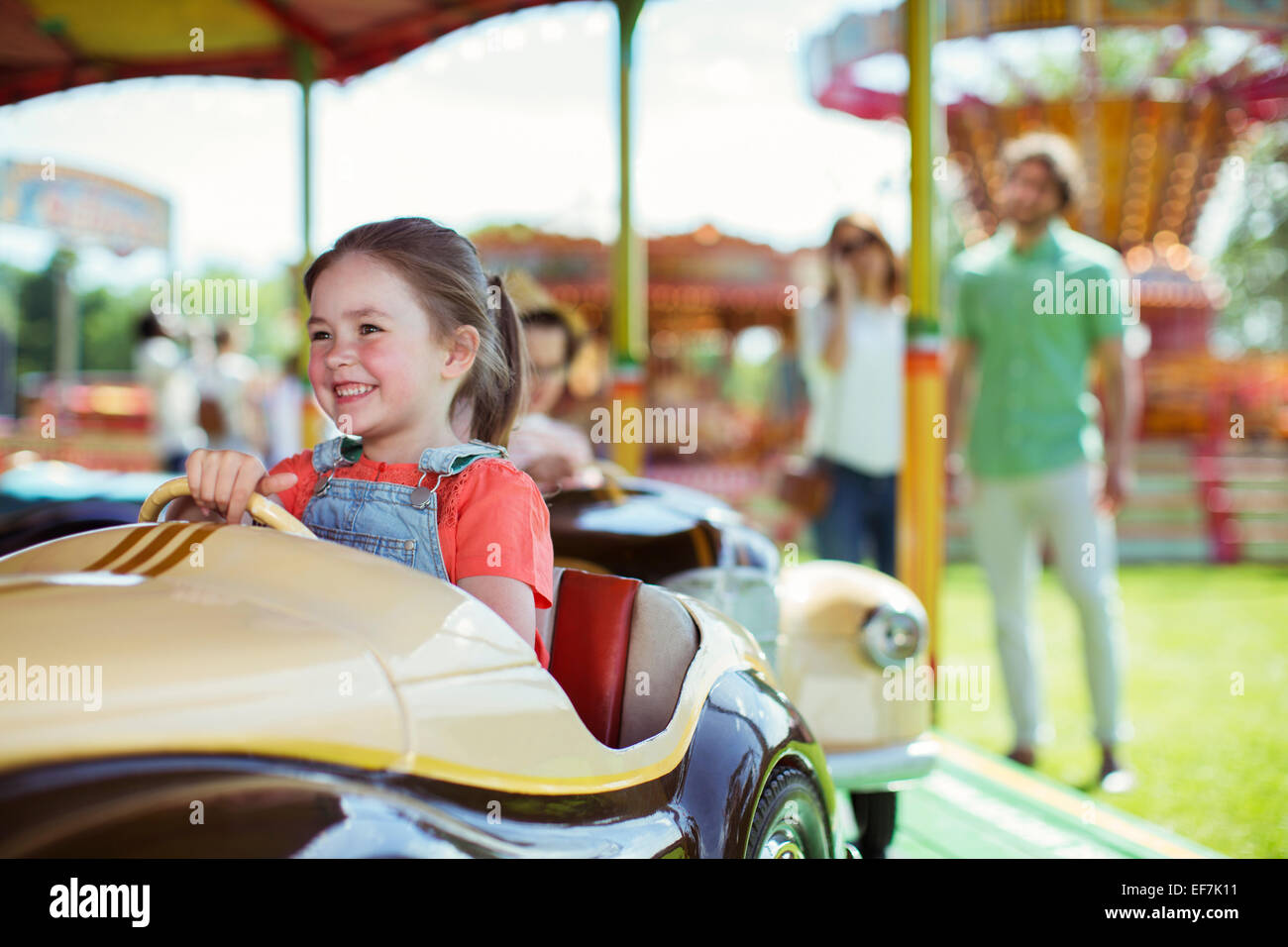 Fröhliches Mädchen auf Karussell im Vergnügungspark Stockfoto