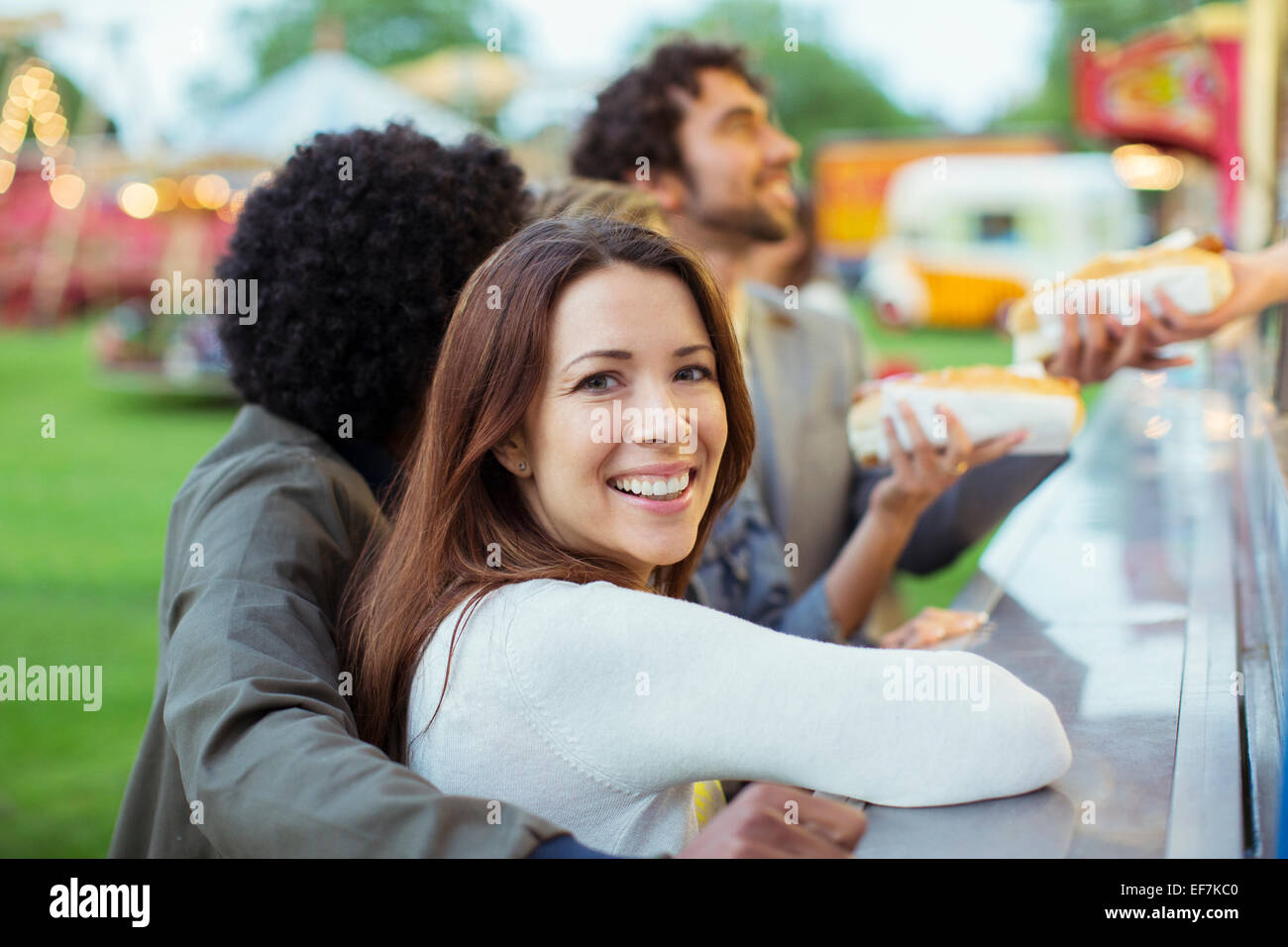 Menschen kaufen Hotdogs in Essen stehen im Freizeitpark Stockfoto