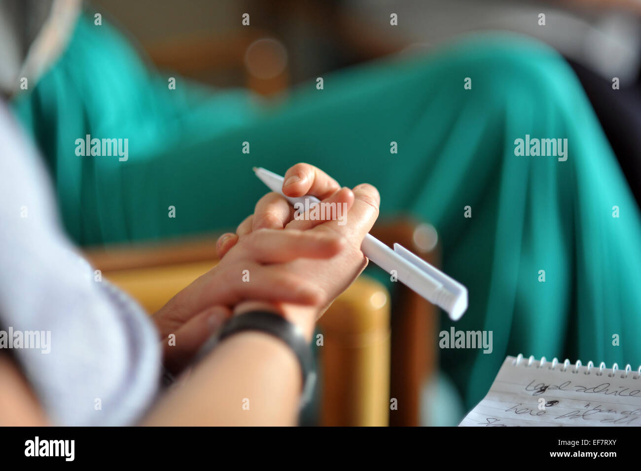 Nahaufnahme der einen Hand und einen Stift in einer Frauengruppe Zentrum Therapie Unterstützung. Stockfoto