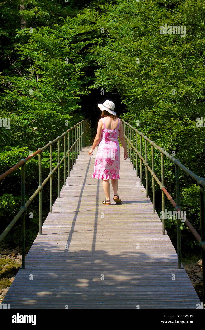 Frau zu Fuß über die Brücke. Gilsland-Spa-Hotel. Gilsland, Cumbria, England, UK. Stockfoto