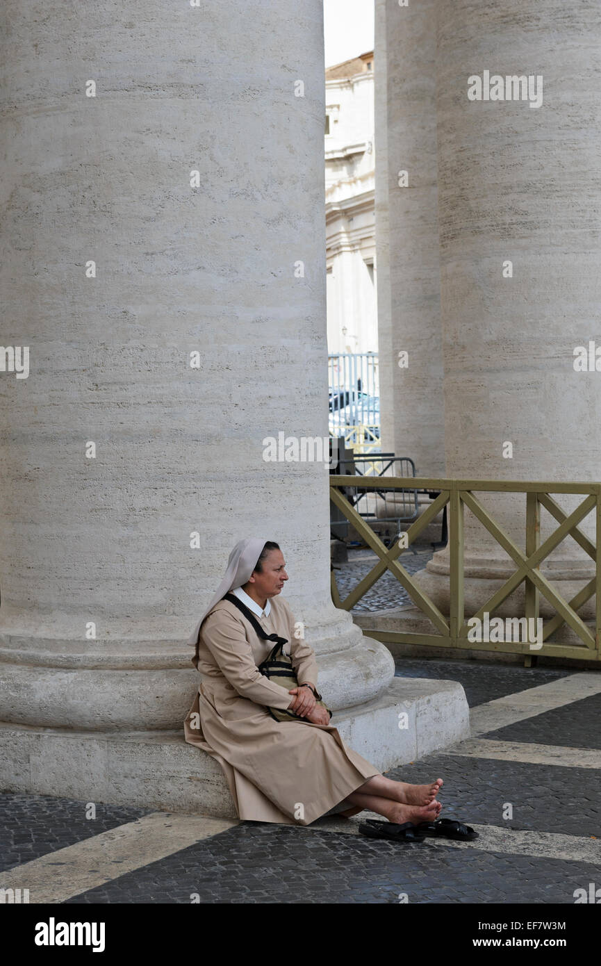 Eine Nonne ruhen nach der Spalte von der Kolonnade in St.-Peter Platzes, Vatikanstadt, Rom, Italien. Stockfoto