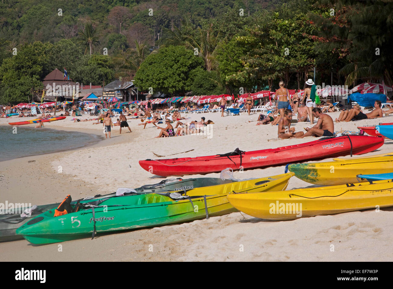 Bunte Kanus und westliche Touristen Sonnenbaden am Strand eines Ko Phi Phi Inseln, Süd-Thailand Stockfoto