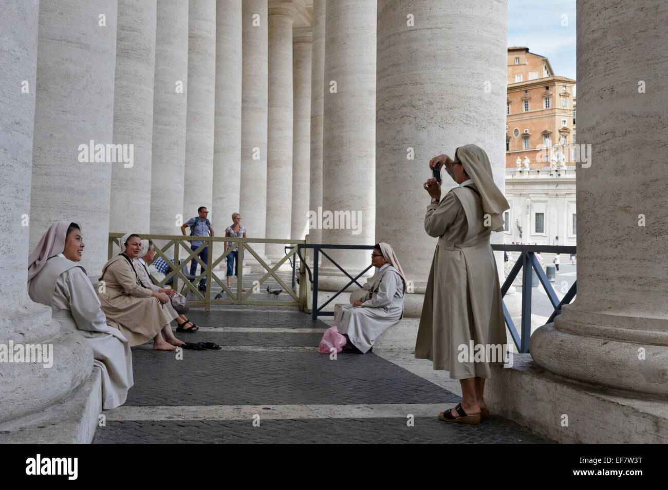 Eine Nonne, fotografieren ihr Nonne Freunde durch die Spalten der Kolonnade in St.-Peter Platzes, Vatikanstadt, Rom, Italien. Stockfoto