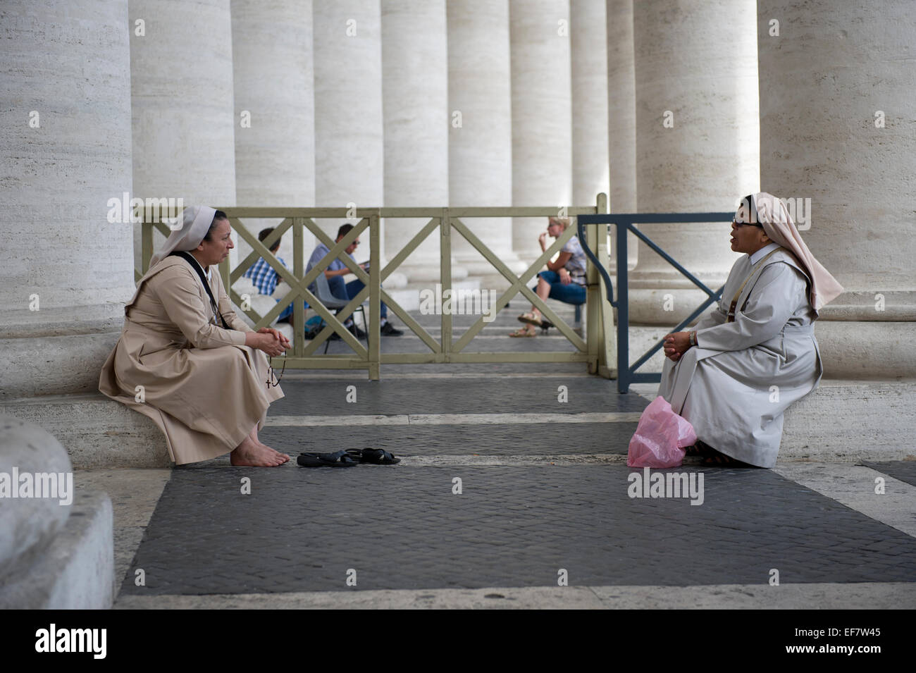 Zwei Nonnen ruhen und sprechen durch die Spalten der Kolonnade in St.-Peter Platzes, Vatikanstadt, Rom, Italien. Stockfoto