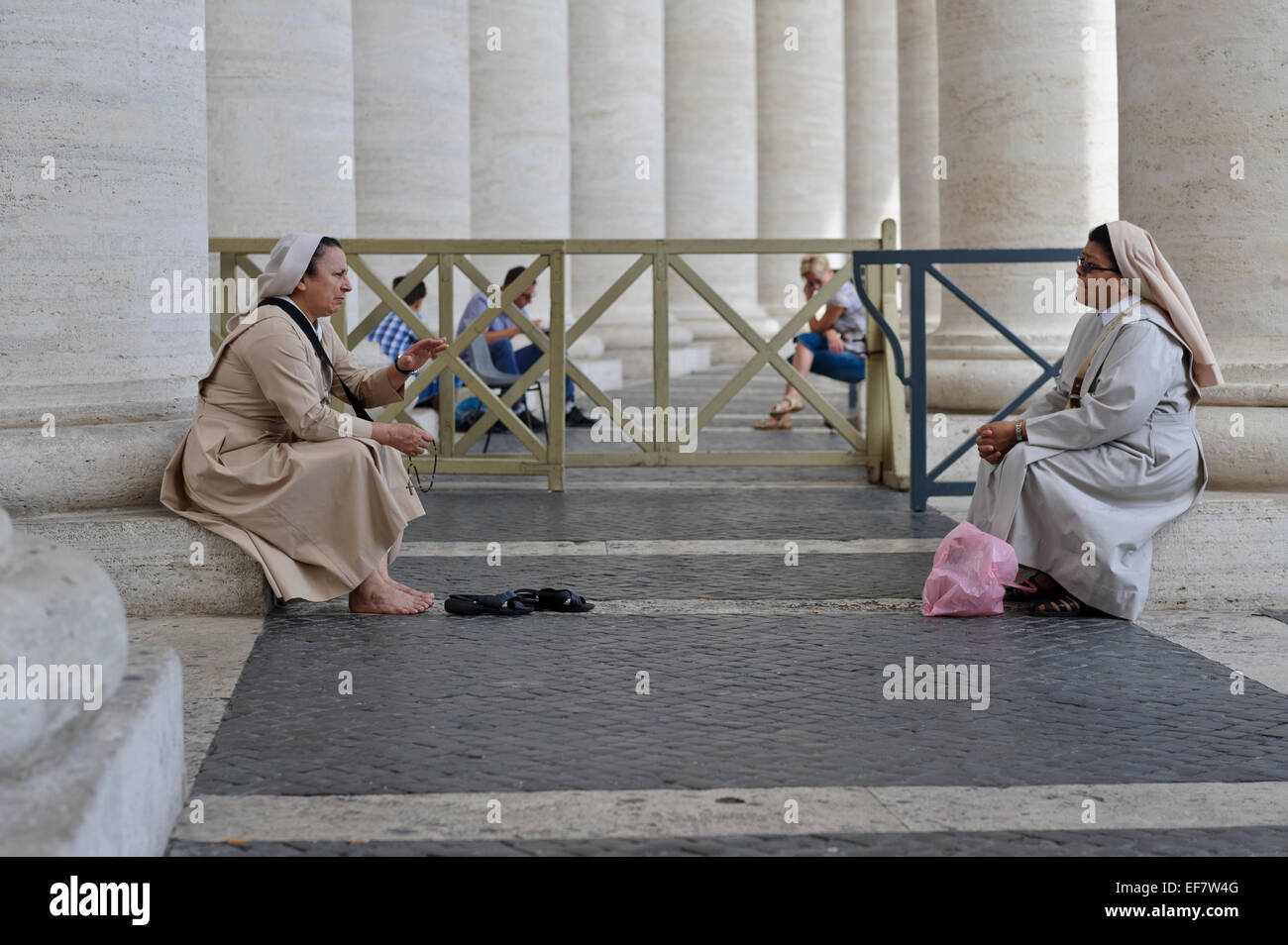 Zwei Nonnen ruhen und sprechen durch die Spalten der Kolonnade in St.-Peter Platzes, Vatikanstadt, Rom, Italien. Stockfoto