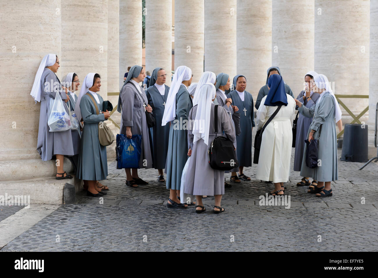 Eine Gruppe von Nonnen durch die Spalten der Kolonnade in St.-Peter Platzes, Vatikanstadt, Rom, Italien gesammelt. Stockfoto