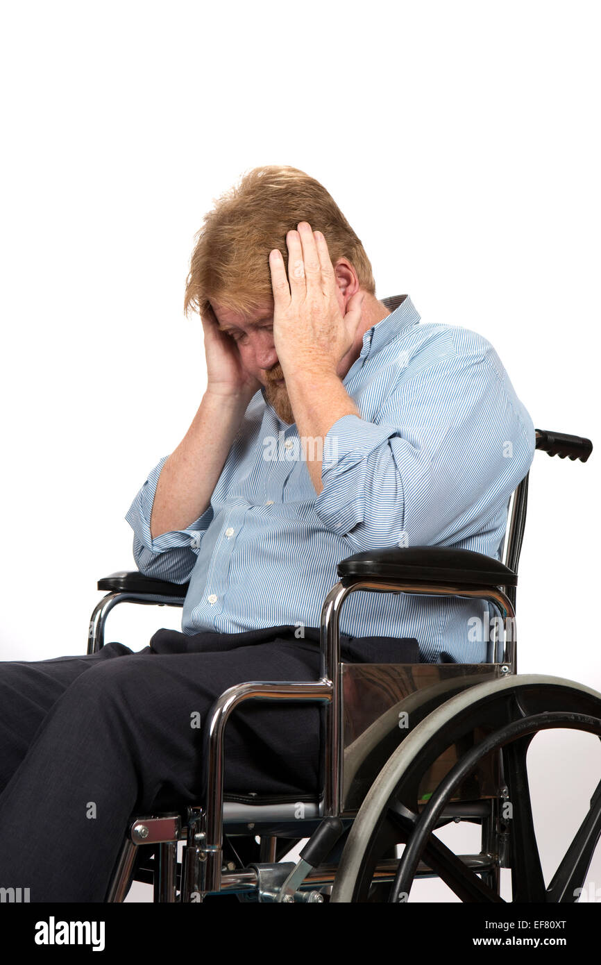 Ältere querschnittsgelähmt im Rollstuhl hält den Kopf in seinen Händen, da er wegen eines medizinischen Problems an Depressionen leidet. Stockfoto