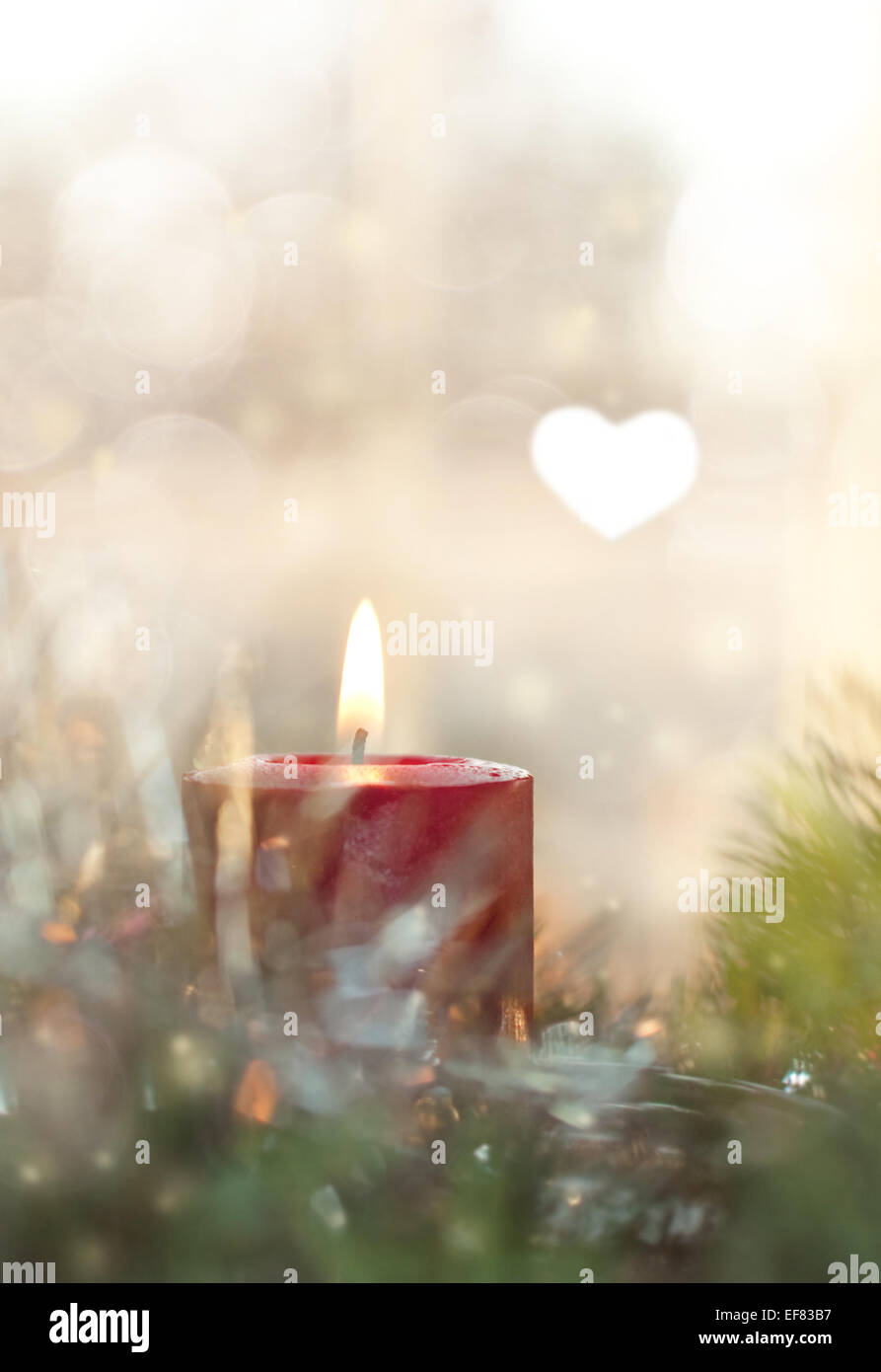 Verträumte Bild einer Rot Weihnachten Kerze brennen, umgeben von einem Kranz und Dekoration Stockfoto