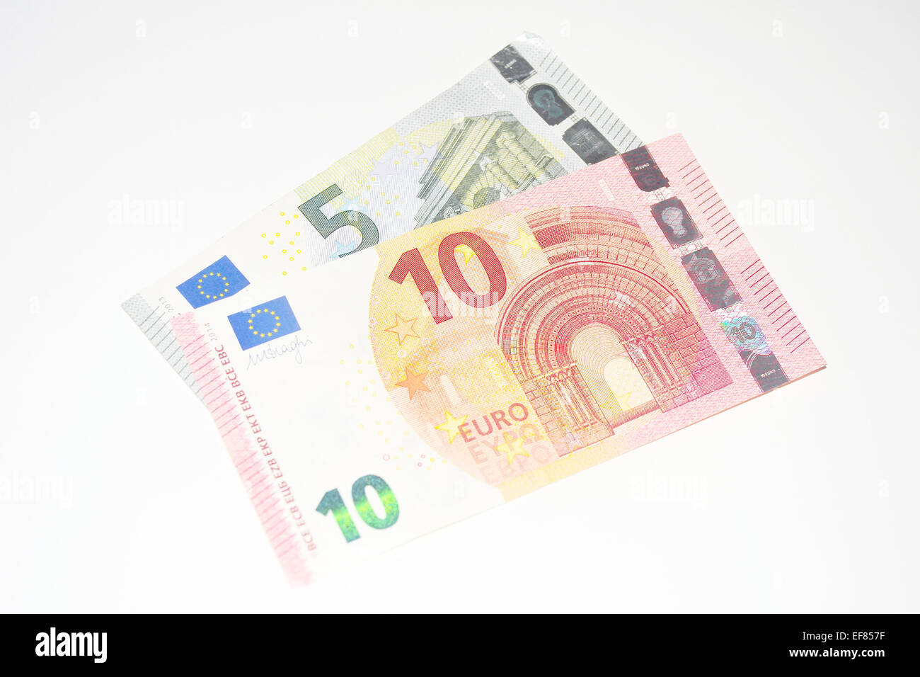 Europäische 5 Euro und 10 Euro-Banknoten vor weißem Hintergrund fotografiert. Stockfoto