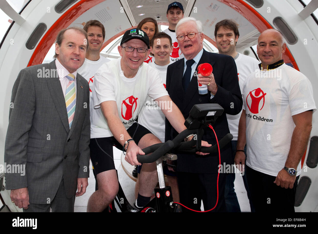 L-R Douglas Rouse, Corporate Partnerschaften Director von Save the Children, Bernie Hollywood, Lloyds-Mitarbeiter, die die Herausforderung auf Fahrrad und Sir Win Bischoff, Lloyds Banking Group Chairmain eingerichtet. Heute, werden 3. November Lloyds Banking Group Mitarbeiter an 38 Standorten die Extrameile für "Save the Children" durch den Abschluss einer 24-Stunden "Around the World" statische Zyklus Herausforderung. Von 10:00 wird das Londoner Team Radsport werden in einer Kapsel von der EDF Energy London Eye (und in einem Zelt, wenn das Auge geschlossen ist). Während dieser 24-Stunden-Challenge hoffe sie GBP 100.000 zu erhöhen, mit dem Fahrrad 18.297 Meilen auf statische Stockfoto