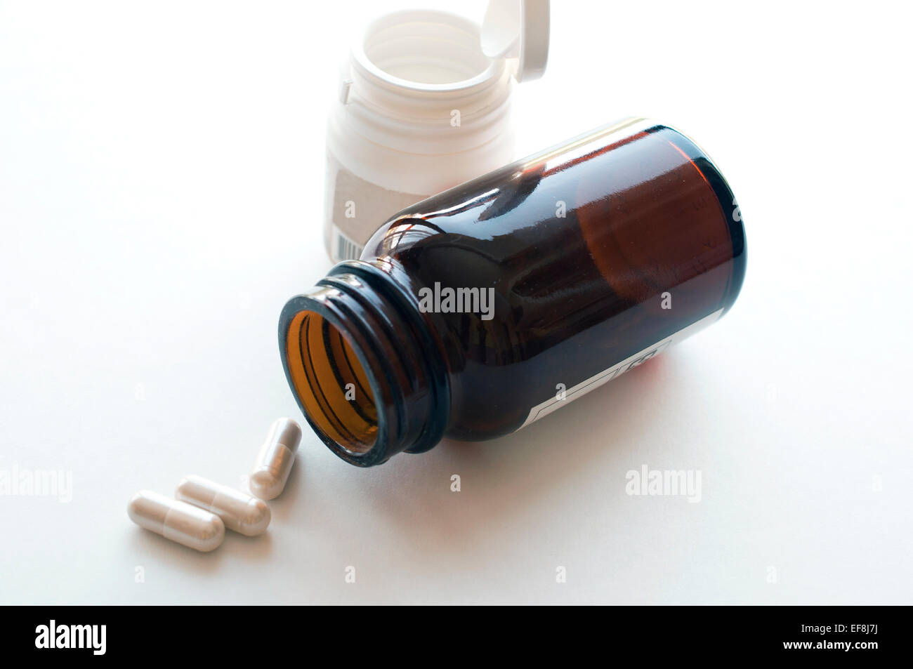 Pillen aus Flasche auf dem weißen Stockfoto