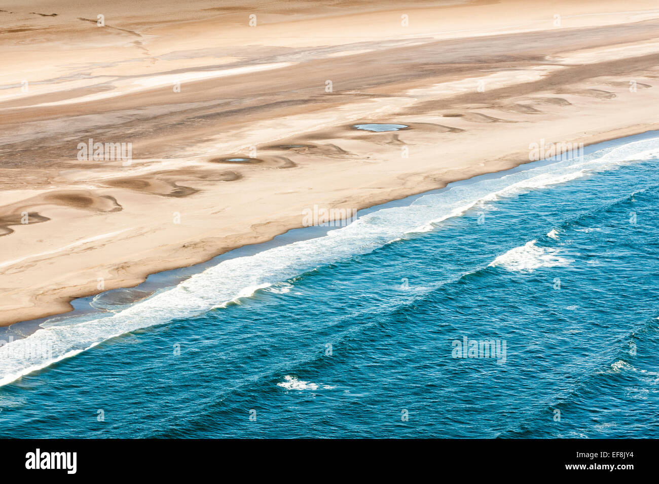 Sand und Meer aufeinander treffen auf die Skeleton Coast an der westlichen Grenze von Namibia Stockfoto