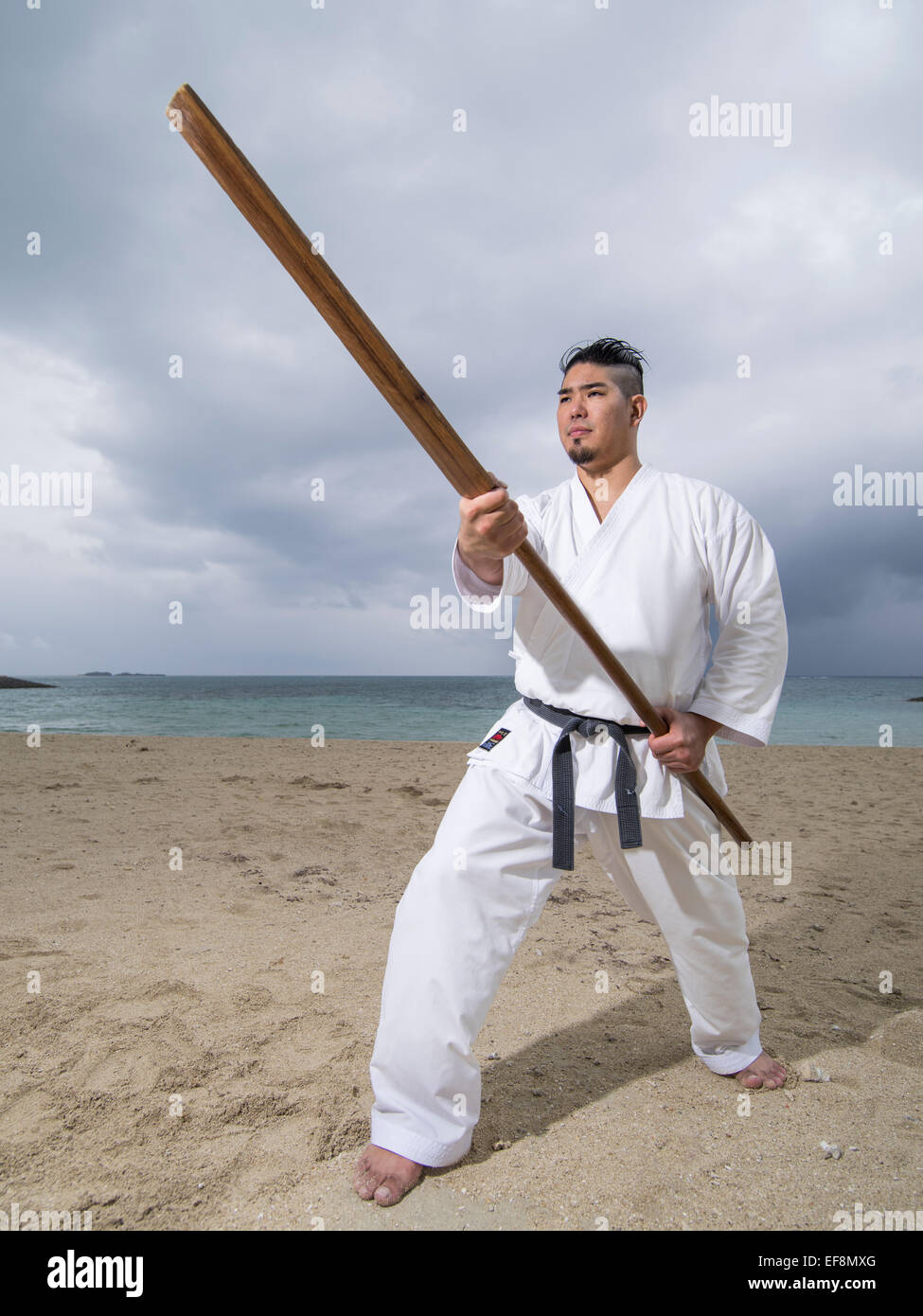 Fumiya Matayoshi mit Eku (Ruder) Ausbildung in Kobudo / Karate am Strand in Okinawa Japan. Stockfoto