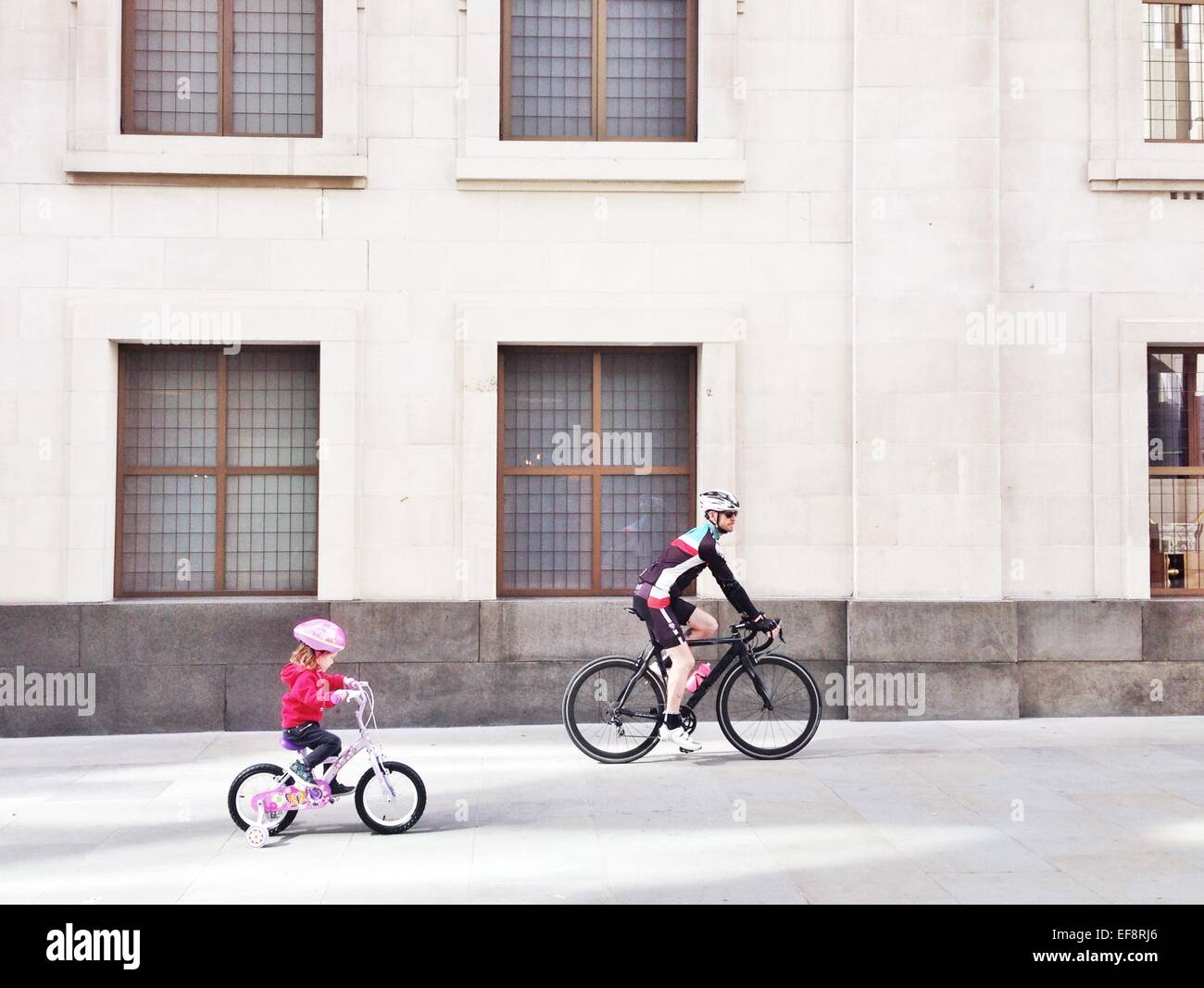 UK, England, London, Vater und Tochter-Gebäude vorbei Radfahren Stockfoto