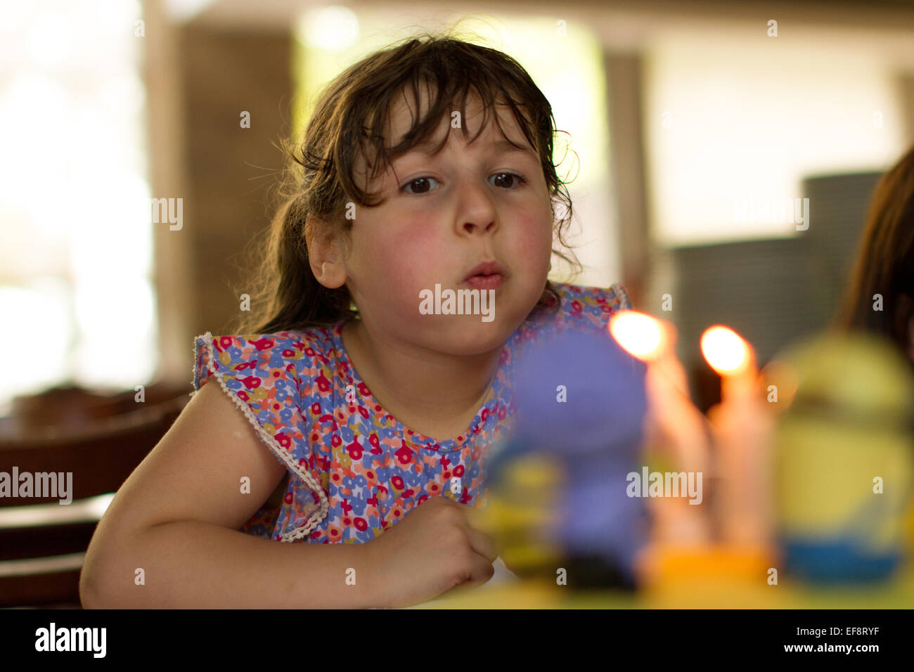 Mädchen bläst Kerzen auf ihrem Geburtstagskuchen Stockfoto