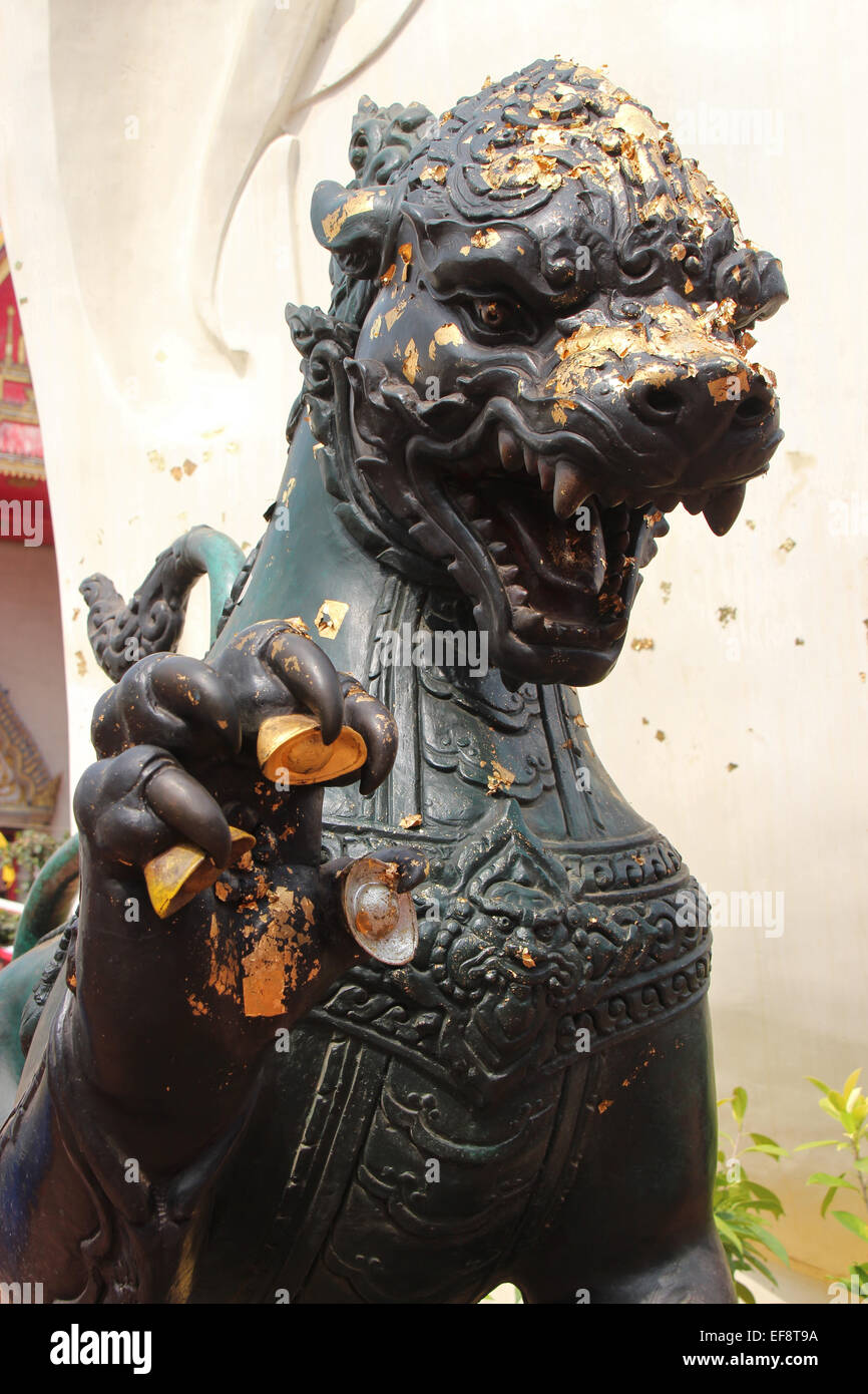 Goldene Blätter wurden auf eine Löwenstatue installiert im Hof des Wihan Phra Mongkons Bophit in Ayutthaya, Thailand fest. Stockfoto