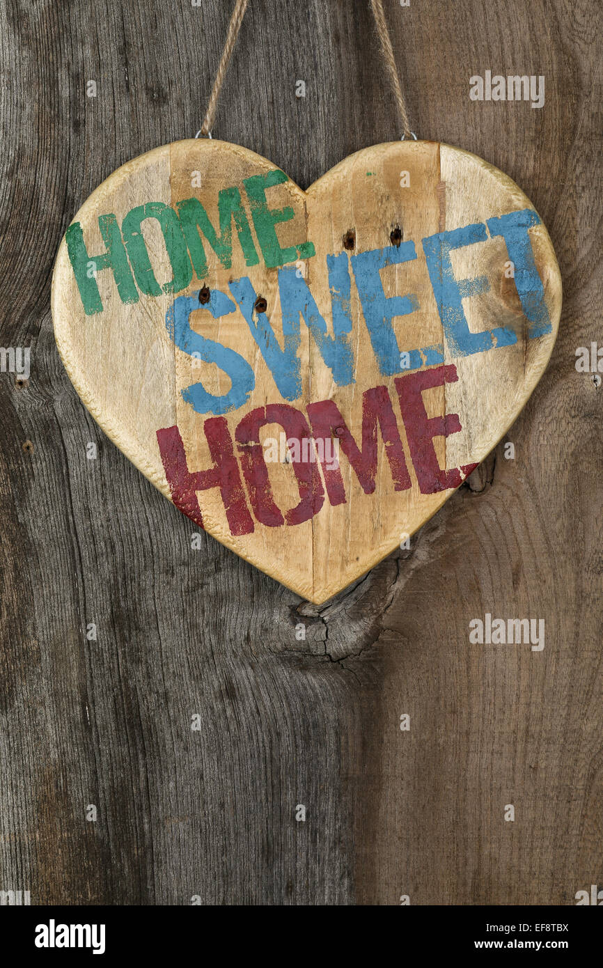 "Home Sweet Home" Nachricht aus Holz Herzschild aus recycelten alten Palette auf rauen grauen hölzernen Hintergrund, Textfreiraum Stockfoto