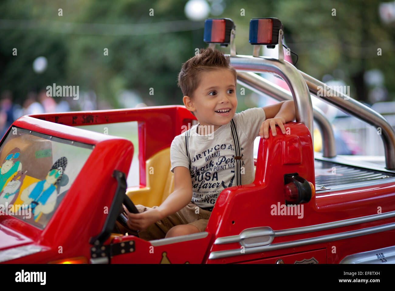 Junge (4-5) Steuerwagen im Vergnügungspark Stockfoto