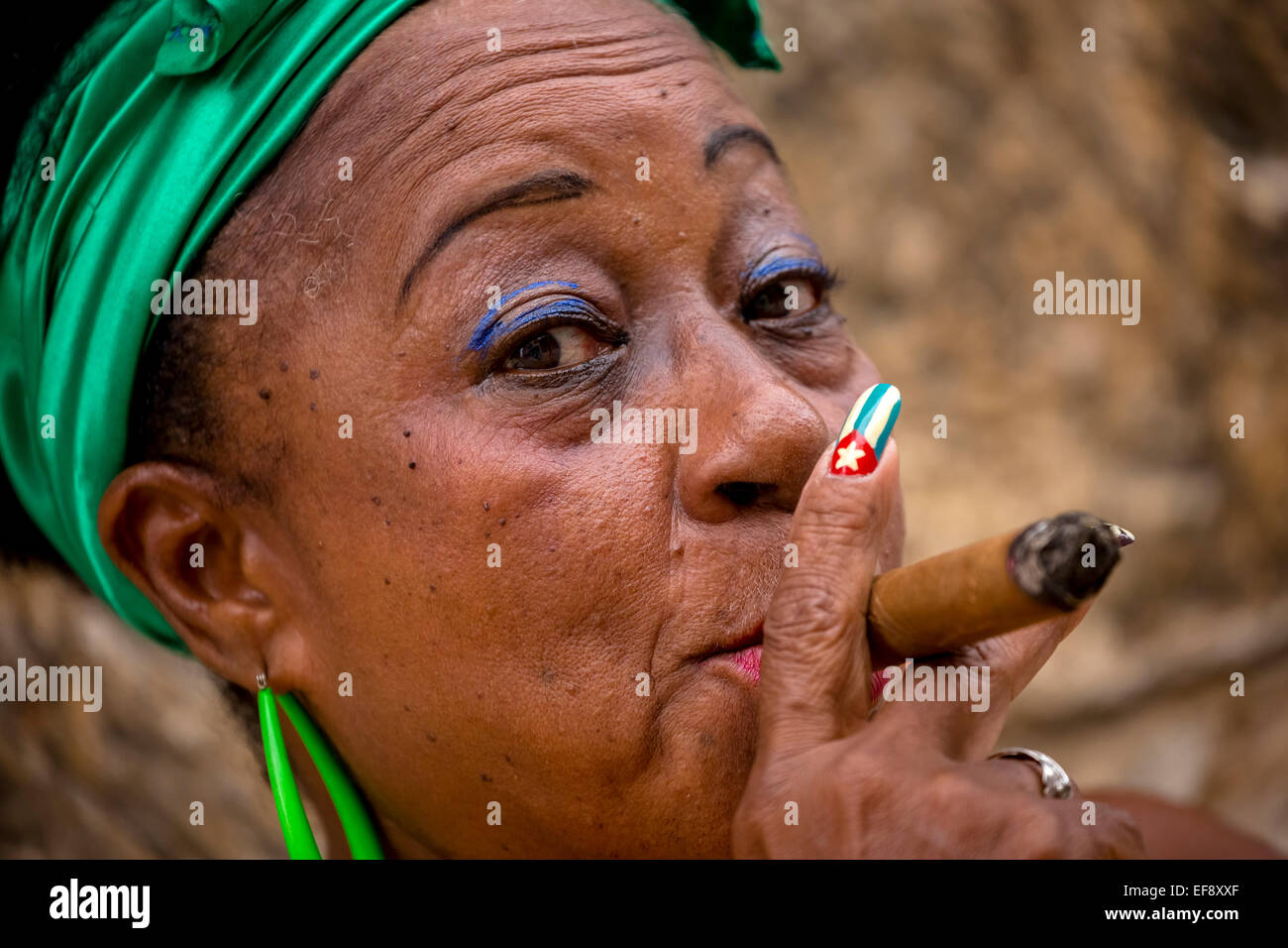 Senior kubanische Frau mit der kubanischen Flagge gemalt auf ihrem Fingernagel eine kubanische Zigarre rauchend, Havanna, Kuba Stockfoto