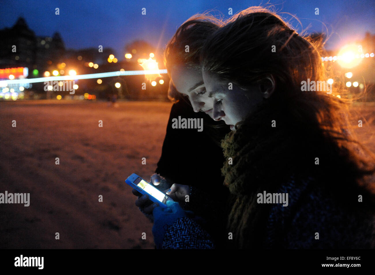 Zwei Mädchen im Teenageralter Englisch SMS und Gesicht Buchung am Strand von Scarborough Stockfoto