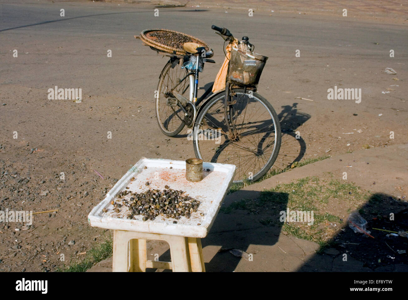 Schnecken sind erhältlich als Speiselokal in der Nähe ein Fahrrad von einem Anbieter verwendet, um sie auf eine Stadt Straße in Kampong Cham, Kambodscha zu verkaufen. Stockfoto