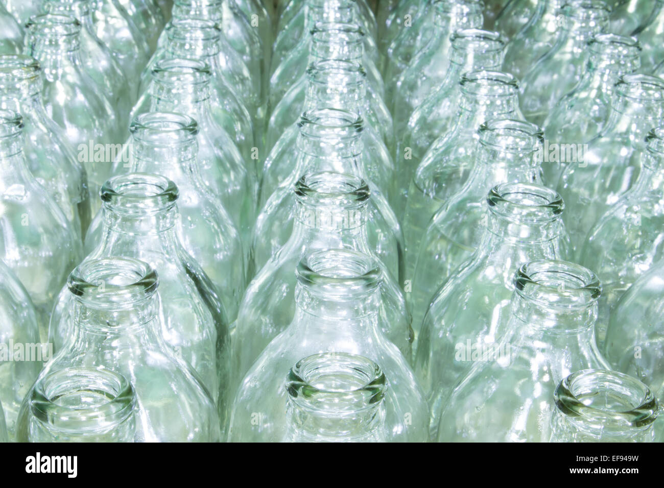 Farbloses Glasflasche gefüllt mit Wasser, die an unterschiedliche vertikale Öffnung platziert. Stockfoto