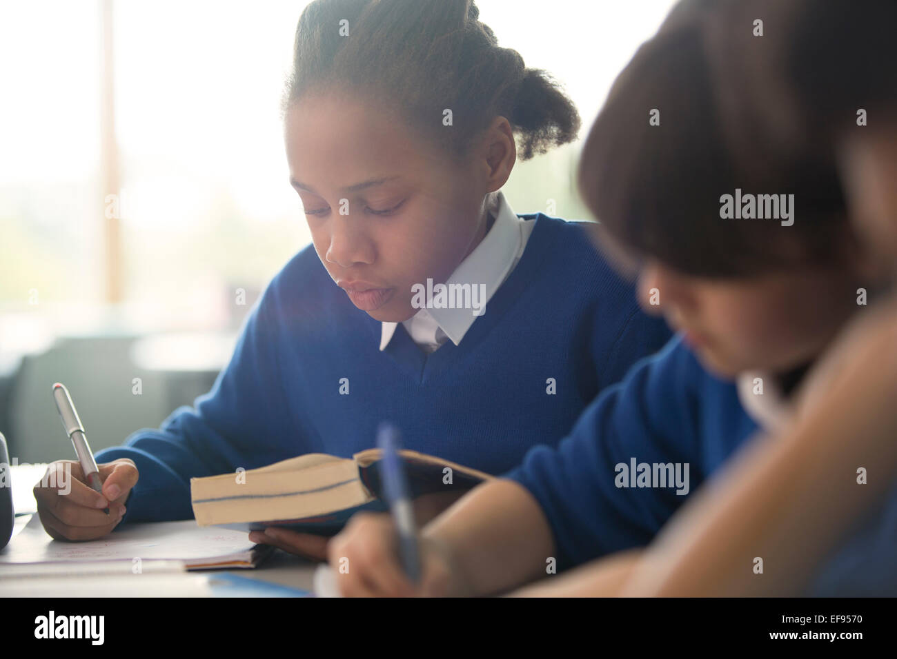 Kinder im Grundschulalter schreiben im Klassenzimmer Stockfoto