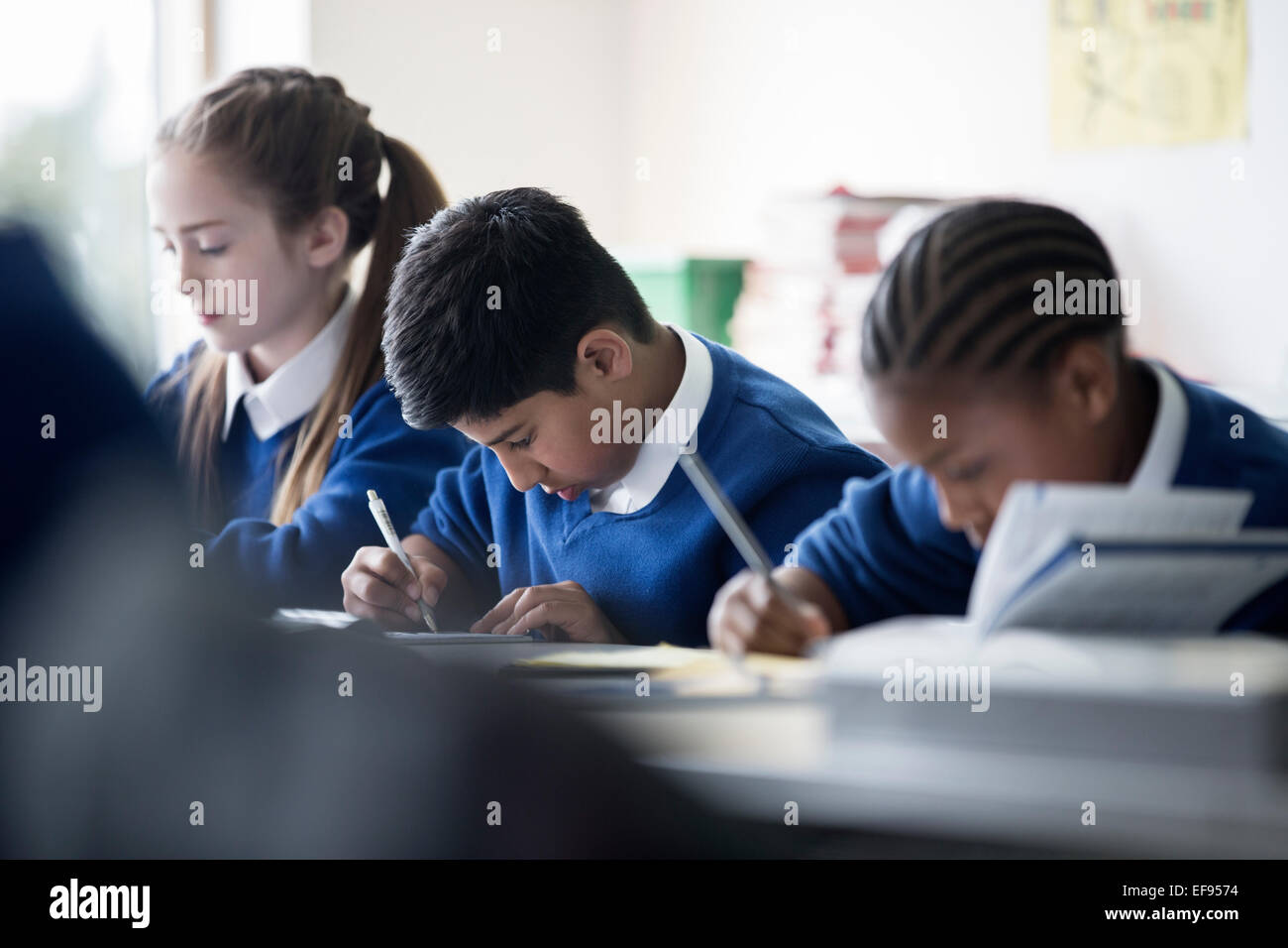 Grundschulkinder schreiben im Klassenzimmer Stockfoto