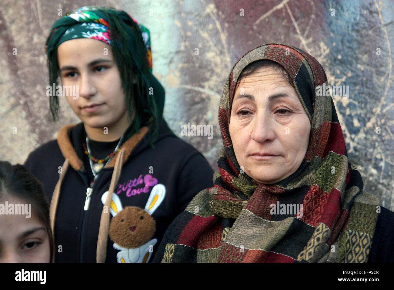 Adla Hasso (r), ein Bewohner von Kobane, steht neben einem jungen unbekannten Mädchen in Stadt Kobane, Syrien, 28. Januar 2015.  Hasso blieb in der Stadt in den letzten vier Monaten bei schweren Kämpfen zwischen kurdischen Kräfte und Kämpfer der sogenannten islamischen Staat (IS) stattfand. Kurdische Kämpfer haben es geschafft, aus der Stadt Kobane IS Kräfte zurückzudrängen.  Raketen und Kampfhandlungen, jedoch haben viele Zivilisten getötet und links die Stadt Kobane völlig verwüstet. Foto: Jan Kuhlmann/dpa Stockfoto