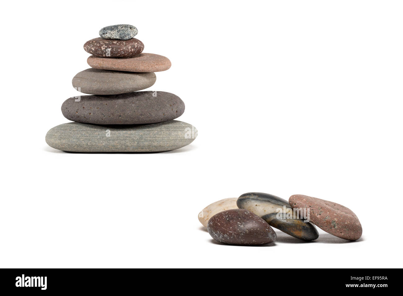 Stein-Cairn aus einer Vielzahl von bunten Lake Superior Felsen gemacht.  Vier zusätzliche Steinen im Vordergrund. Isoliert auf weiss. Stockfoto