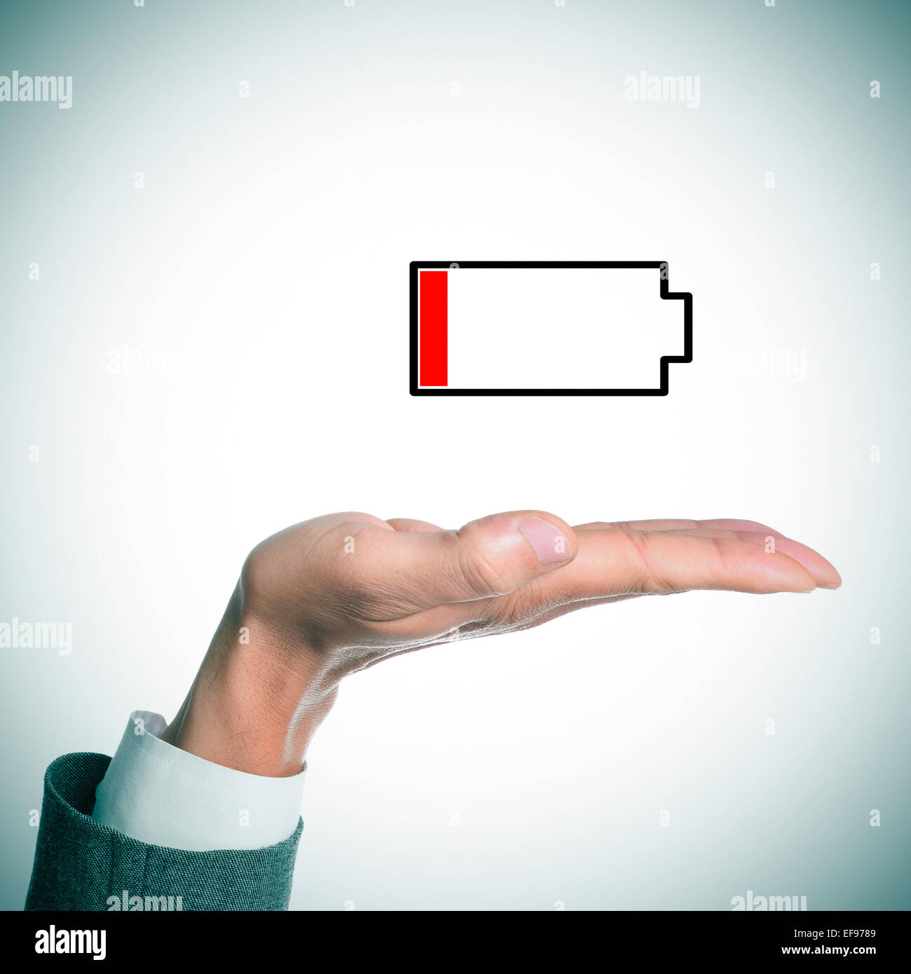 die Hand eines Geschäftsmannes hält ein Beispiel für eine schwache Batterie Stockfoto