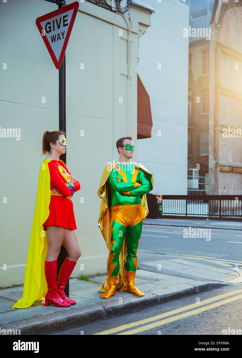 Superhelden-paar wartet am Ecke auf Stadt Bürgersteig Stockfoto