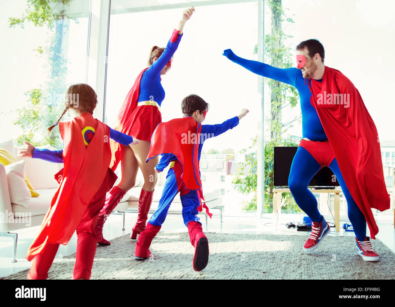 Superhelden-Familie im Wohnzimmer spielen Stockfoto